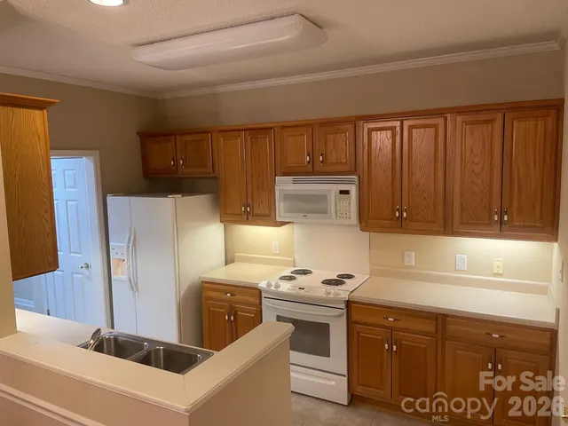 a kitchen with stainless steel appliances a refrigerator a sink and white cabinets