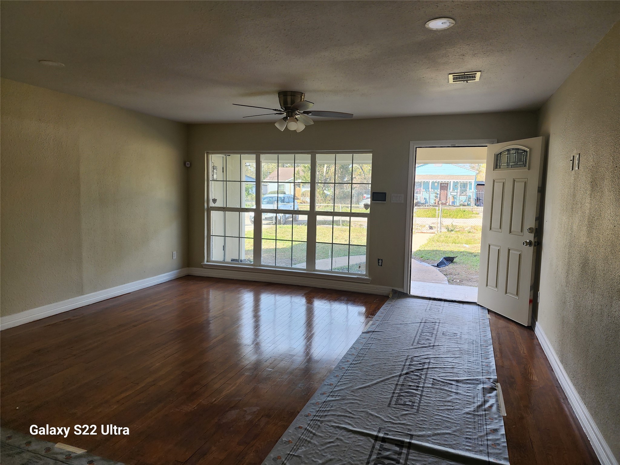 702 McDaniel Street, Unit A Houston, TX 77022 - Photo 3 of 11 an empty room with wooden floor and windows