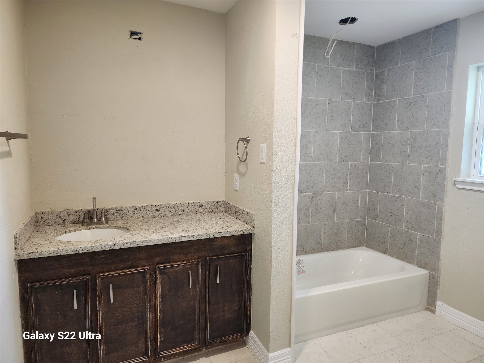 702 McDaniel Street, Unit A Houston, TX 77022 - Photo 9 of 11 a bathroom with a granite countertop sink a mirror and bathtub