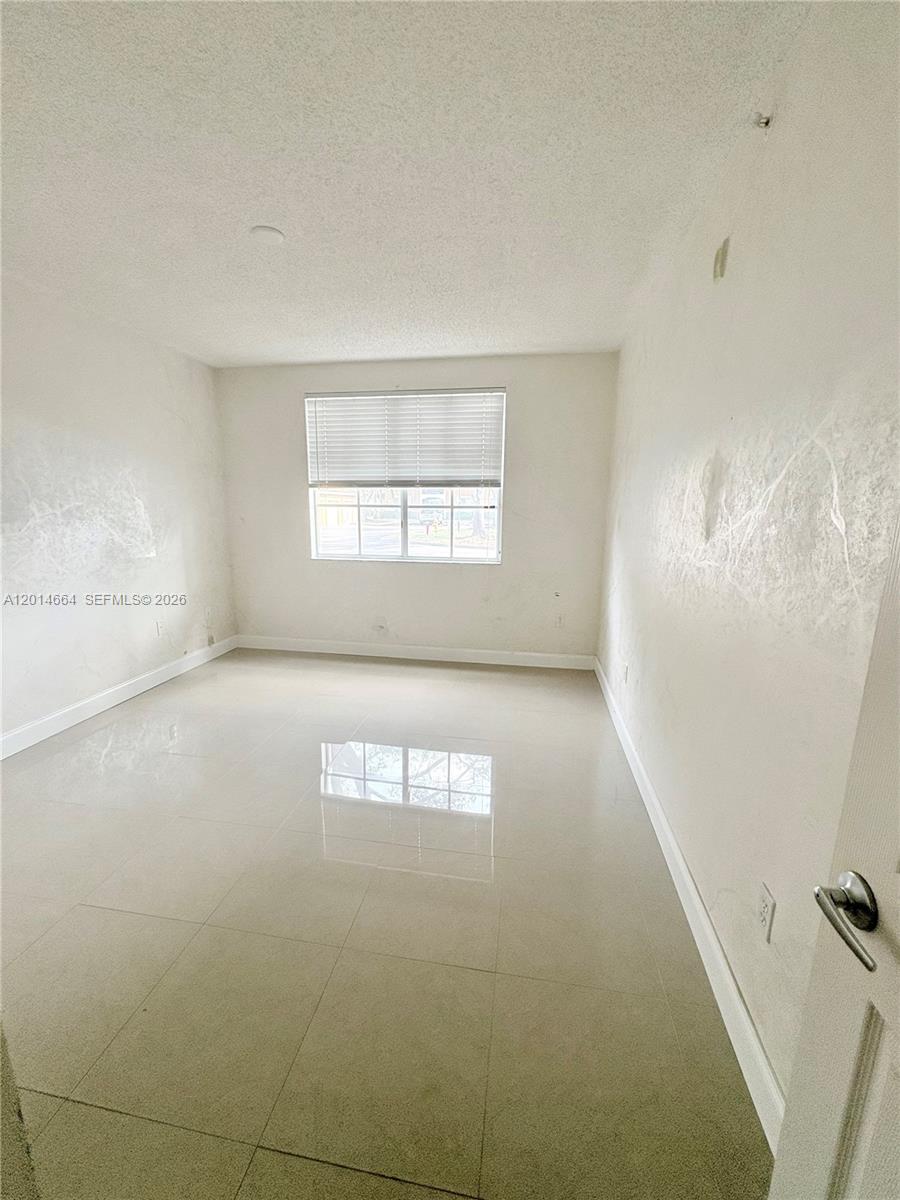8030 North Nob Hill Road, Unit 105 Tamarac, FL 33321 - Photo 9 of 22 an empty room with windows