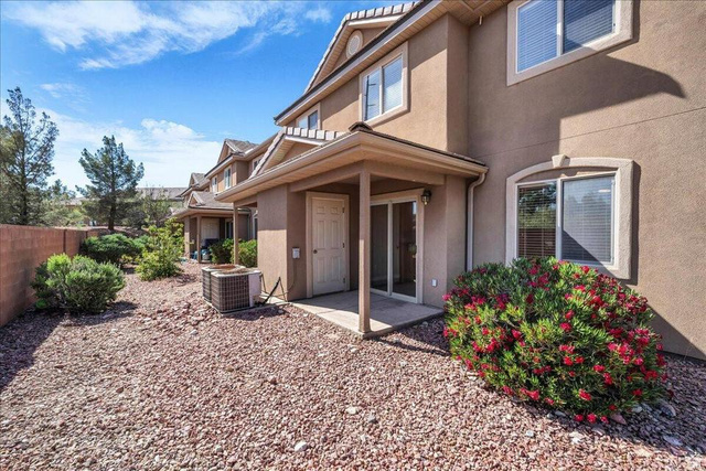 3155 South Hidden Dr Street, Unit 248 St. George, UT 84790 - Photo 17 of 24 Stucco exterior with decorative window trim and a covered patio featuring sliding glass doors