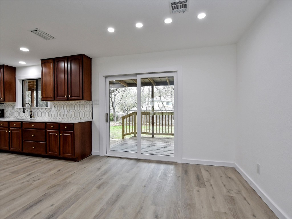 307 Copperleaf Road Lakeway, TX 78734 - Photo 11 of 28 a large kitchen with a large window a sink and a dishwasher with wooden floor