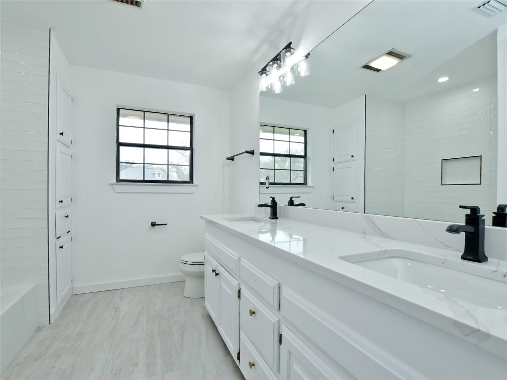 307 Copperleaf Road Lakeway, TX 78734 - Photo 23 of 28 a bathroom with a double vanity sink a toilet and a mirror