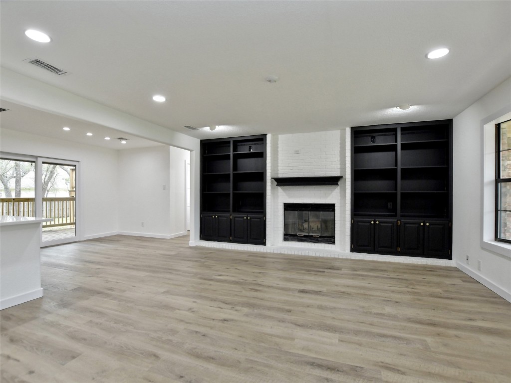 307 Copperleaf Road Lakeway, TX 78734 - Photo 9 of 28 a view of an empty room with a fireplace and a window