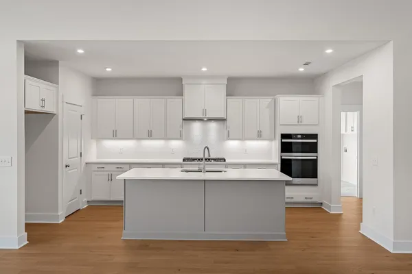 a kitchen with kitchen island stainless steel appliances a stove refrigerator sink and cabinets