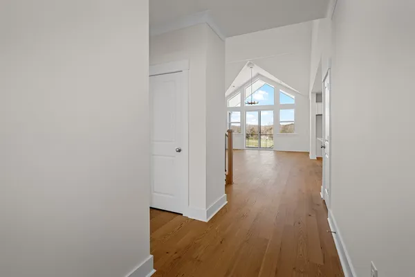 a view of empty room with wooden floor and window