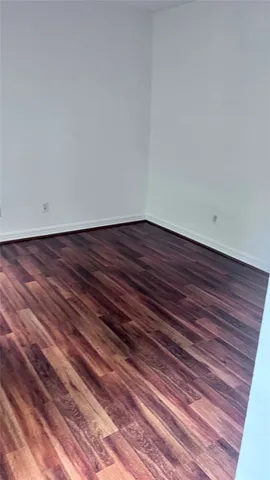 a view of a room with wooden floor and fan