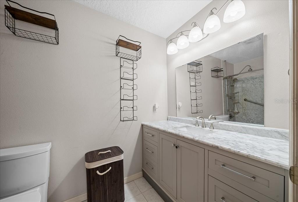 12575 West Edwards Court Inglis, FL 34449 - Photo 19 of 39 a bathroom with a granite countertop sink a mirror and a toilet