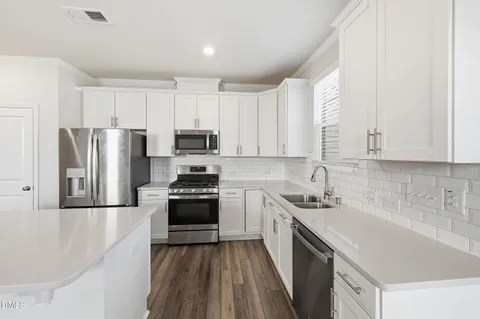 a view of kitchen with wooden floor and electronic appliances