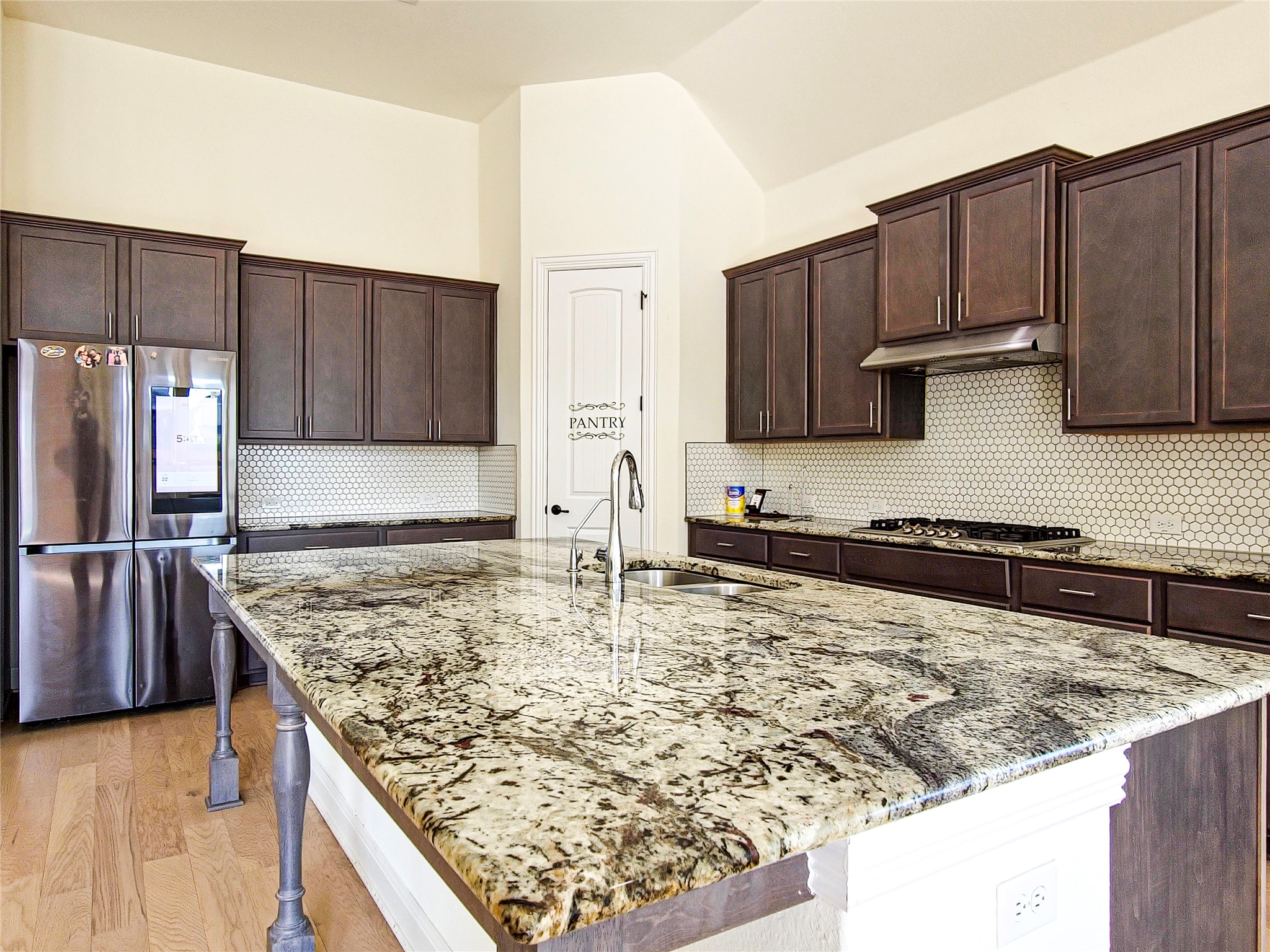 813 Sunny Ridge Drive Leander, TX 78641 - Photo 8 of 32 A well-appointed kitchen features a large granite island and richly stained cabinetry.