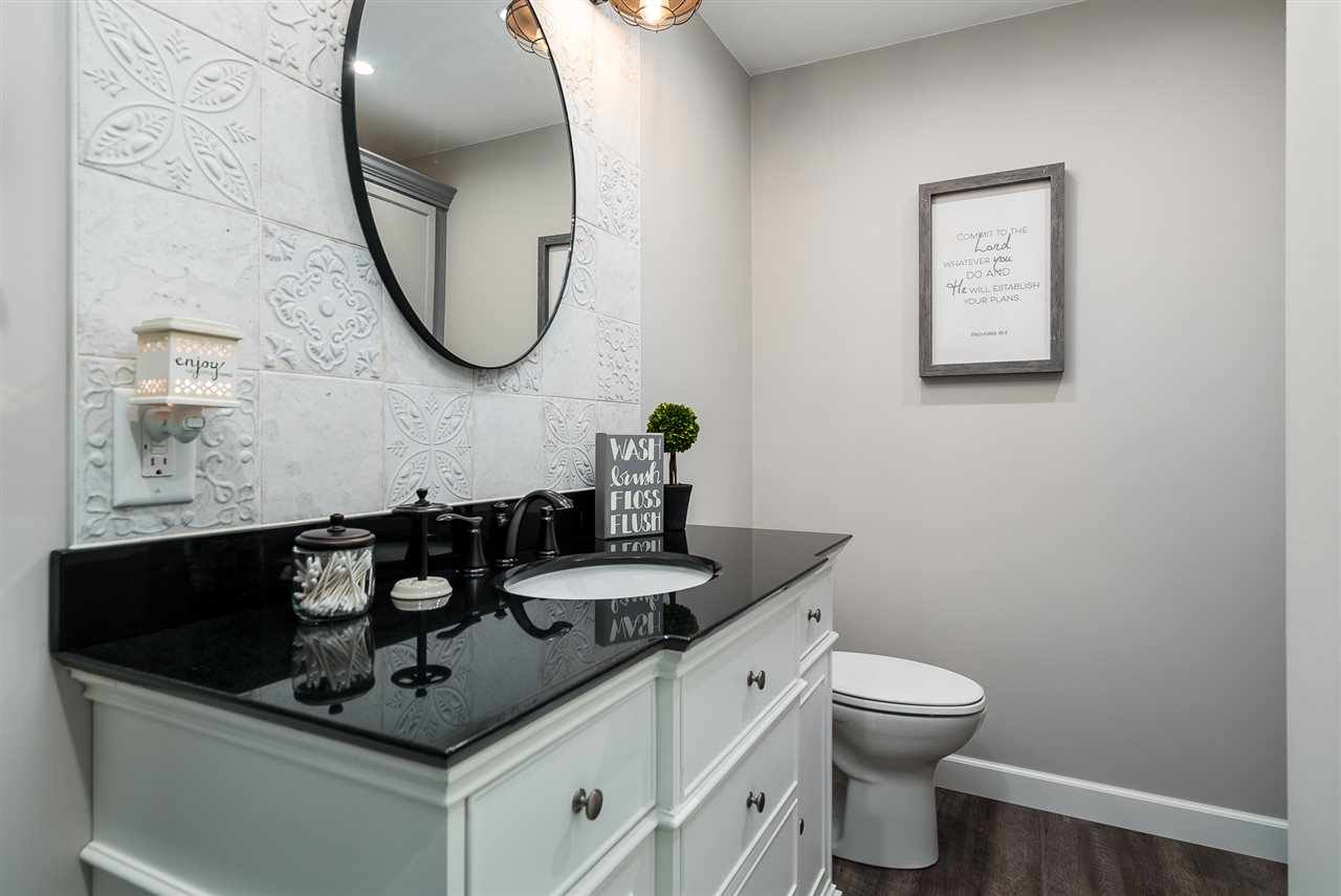 9691 East Cedarville Road Davis, IL 61019 - Photo 31 of 39 a bathroom with a granite countertop toilet a sink and mirror