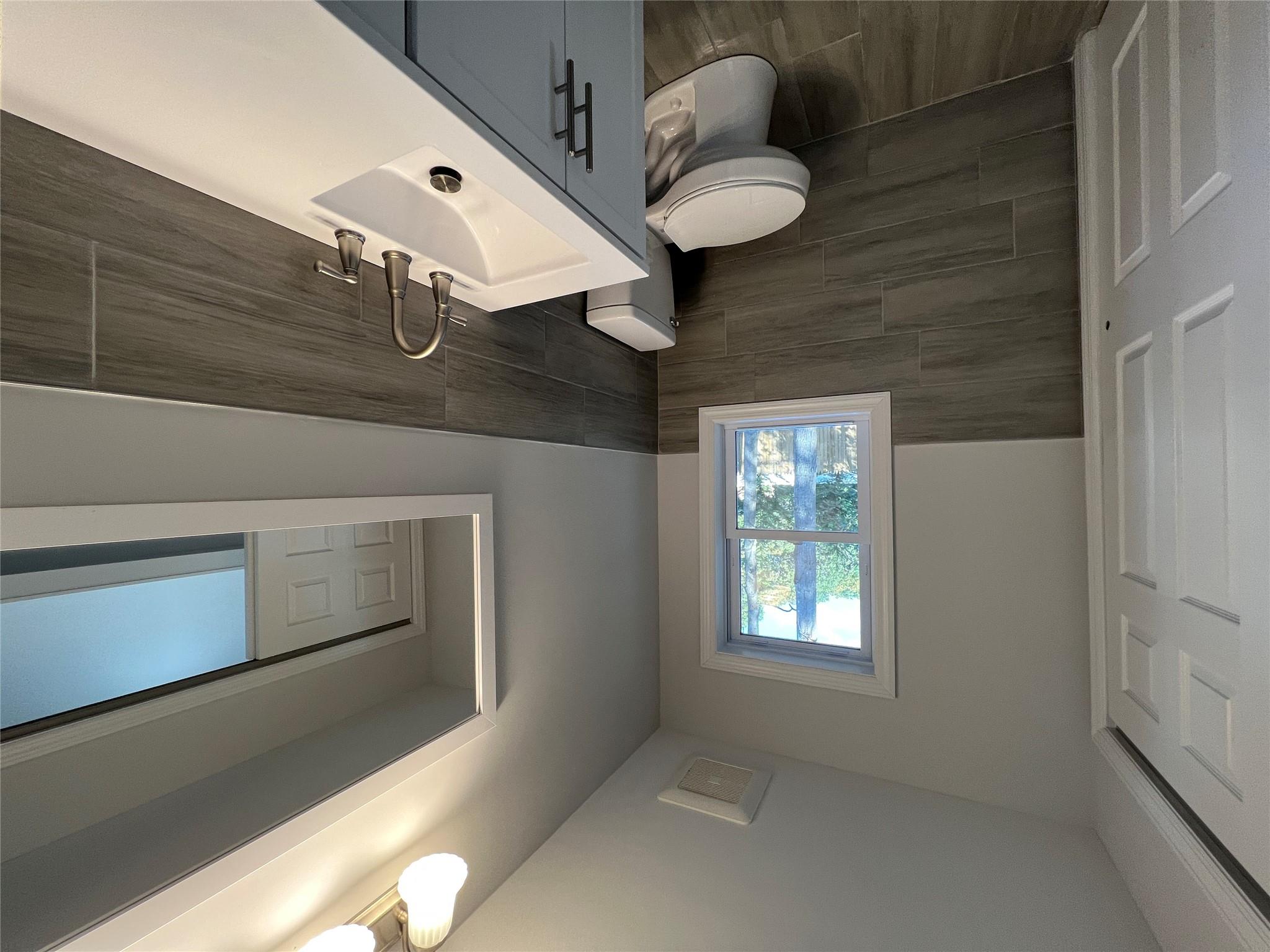 N / C Blue Point Road Farmingville, NY 11738 - Photo 9 of 16 a bathroom with a toilet sink vanity and mirror