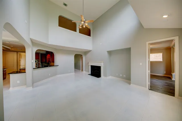 an empty room with ceiling fan and window