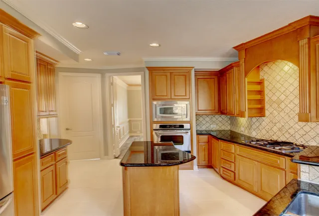 a kitchen with stainless steel appliances granite countertop a stove a sink and a refrigerator