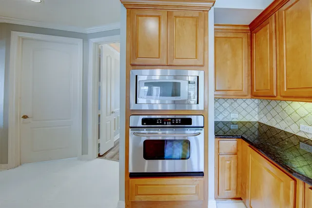 a kitchen with granite countertop cabinets stainless steel appliances and a counter space