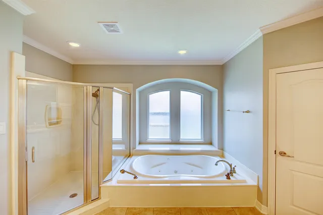 a bathroom with a tub a sink and a window