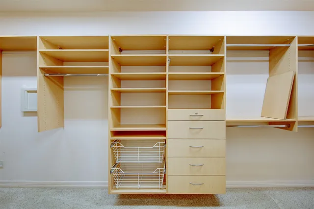 a view of walk in closet with empty racks