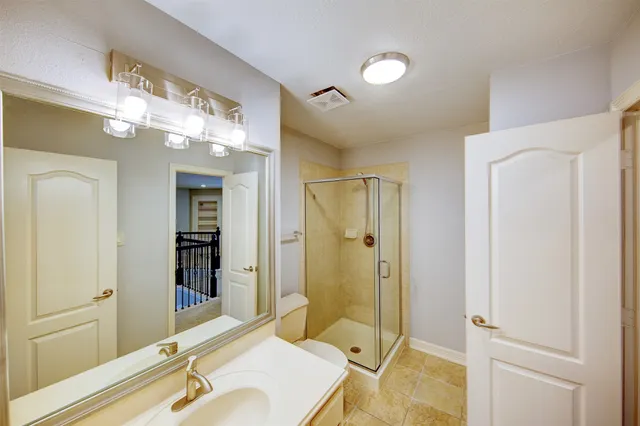 a spacious bathroom with a granite countertop sink mirror and shower