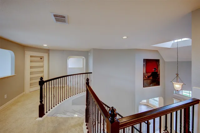 a view of a hallway with wooden floor and stairs