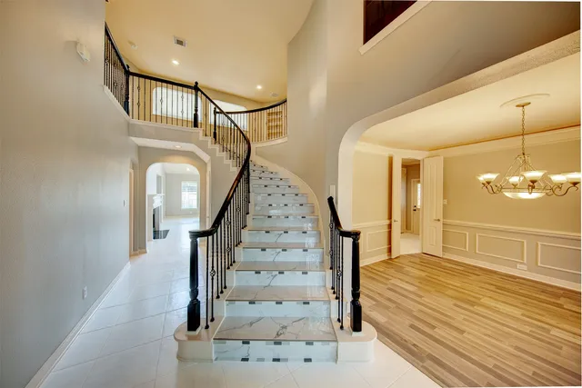 a view of staircase with wooden floor and a chandelier