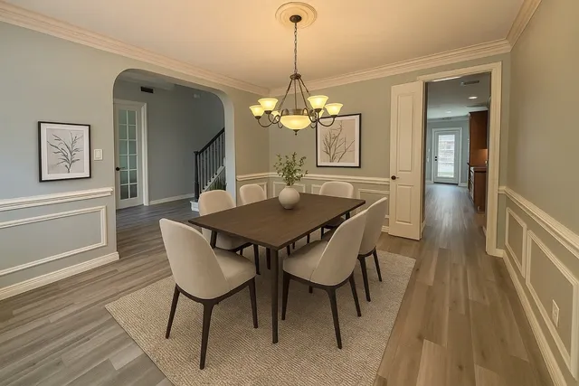 a dining room with furniture a chandelier and wooden floor