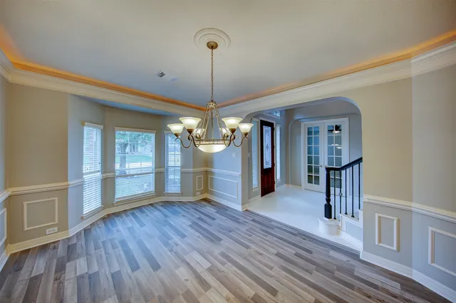 a view of a room with wooden floor staircase and a kitchen