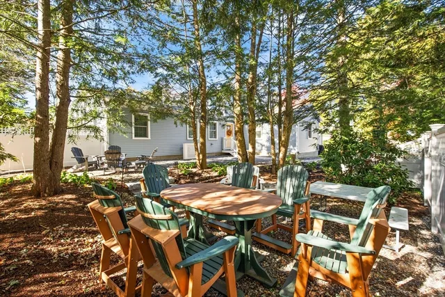 a view of a patio with table and chairs with wooden fence and plants
