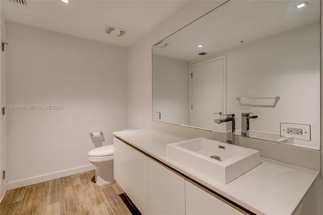 a bathroom with a sink toilet and mirror