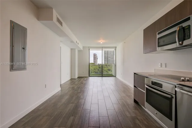 a view of a kitchen with wooden floor and electronic appliances