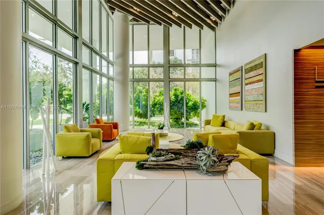 a living room with furniture and floor to ceiling windows