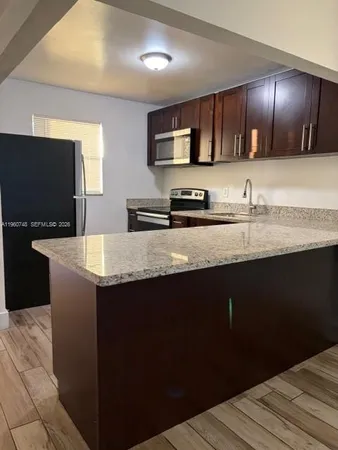 a kitchen with stainless steel appliances wooden cabinets a sink and a dishwasher