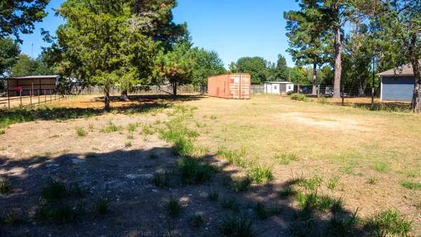 a view of swimming pool with a bench and trees