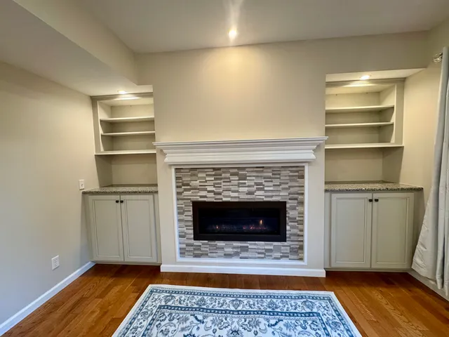 a living room with a fireplace and a rug