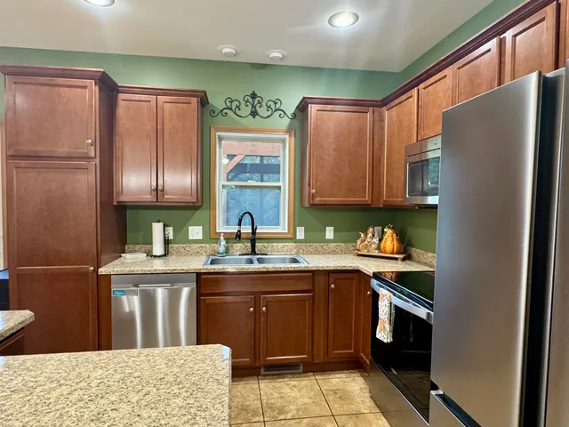 a kitchen with stainless steel appliances granite countertop a refrigerator sink and cabinets