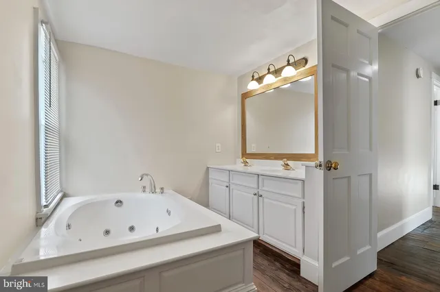 a bathroom with a tub sink and mirror