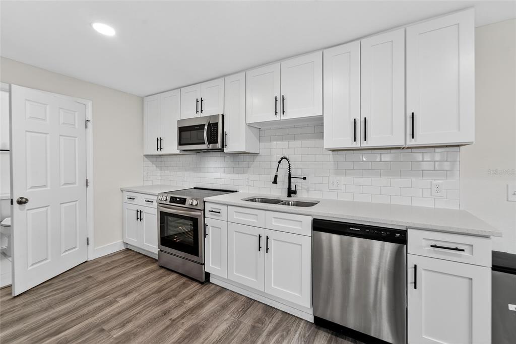 2525 West Beach Street Tampa, FL 33607 - Photo 11 of 48 a kitchen with cabinets stainless steel appliances and wooden floor