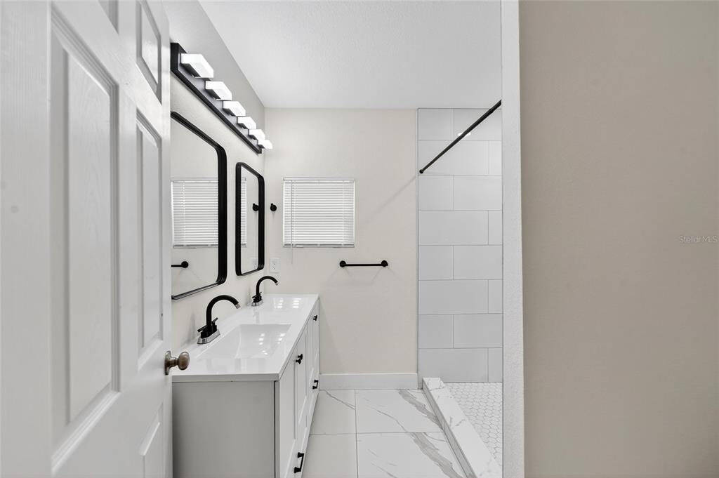 2525 West Beach Street Tampa, FL 33607 - Photo 37 of 48 a bathroom with a sink a mirror and shower