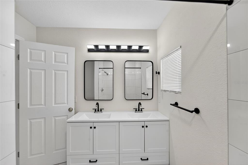 2525 West Beach Street Tampa, FL 33607 - Photo 40 of 48 a bathroom with double vanity sinks and a mirror