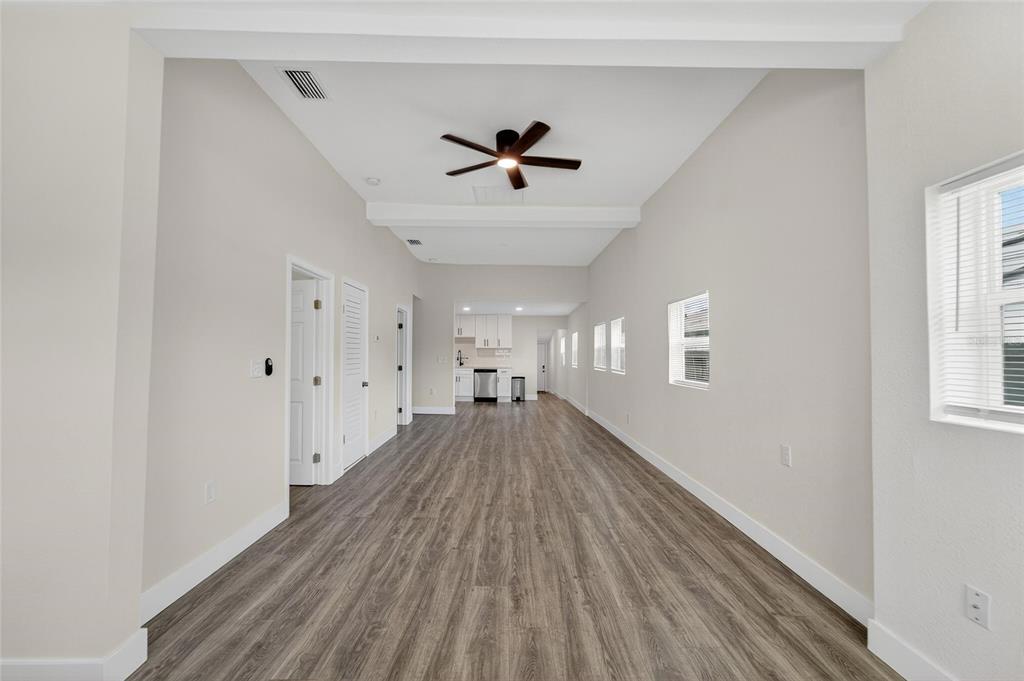 2525 West Beach Street Tampa, FL 33607 - Photo 5 of 48 a view of a big room with wooden floor a ceiling fan and windows