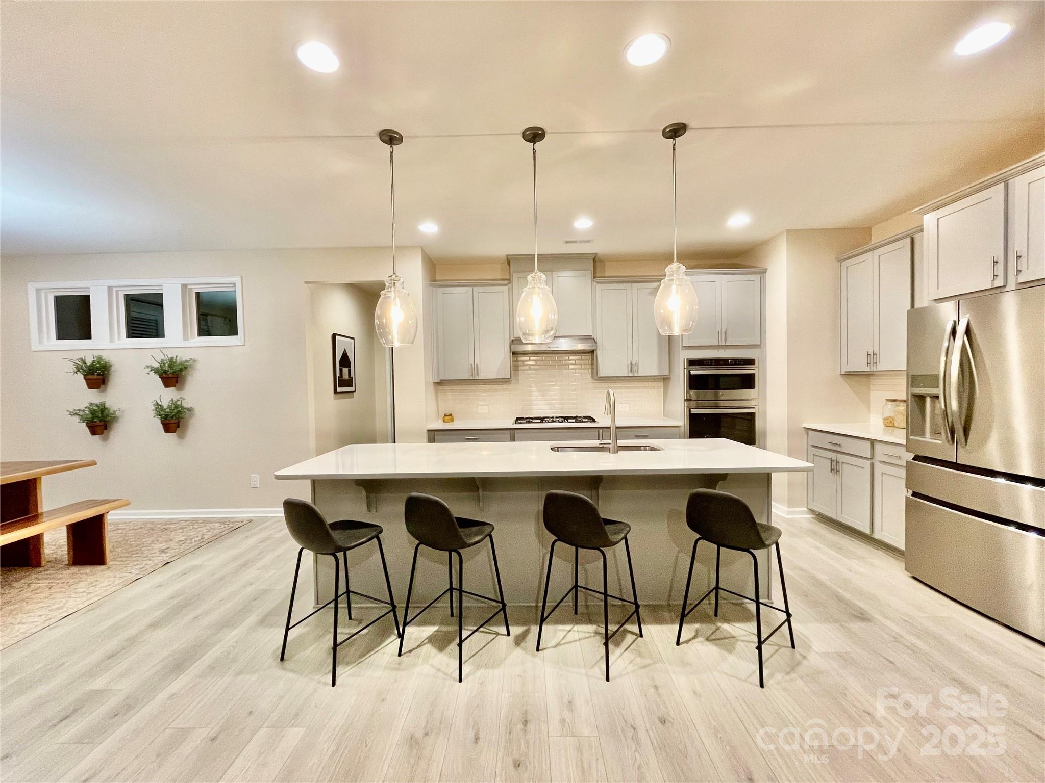 278 West Waterlynn Road Mooresville, NC 28117 - Photo 5 of 46 a kitchen with stainless steel appliances kitchen island granite countertop a table chairs sink and cabinets