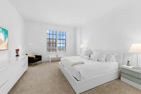 a bedroom with a bed and a painting on the wall