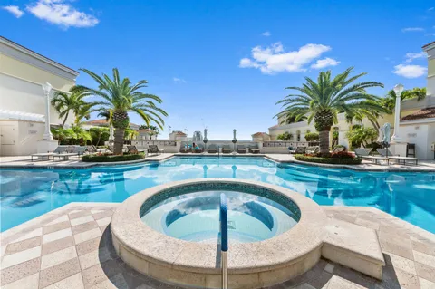 a view of a patio with dining table and chairs with plants and palm trees