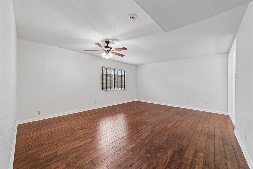 10239 Green Ash Road Dallas, TX 75243 - Photo 31 of 36 Spacious room featuring wood-finish flooring, white walls, and a sloped ceiling