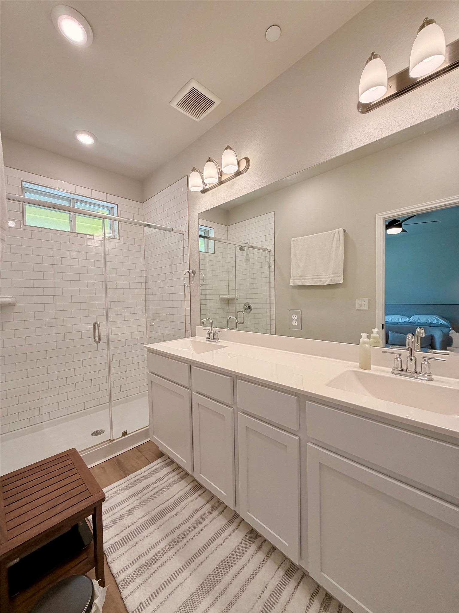 9015 Cattle Baron Path, Unit 1803 Austin, TX 78747 - Photo 11 of 23 Primary ensuite bathroom with double vanity, a spacious standing shower, light wood-style flooring, and recessed lighting
