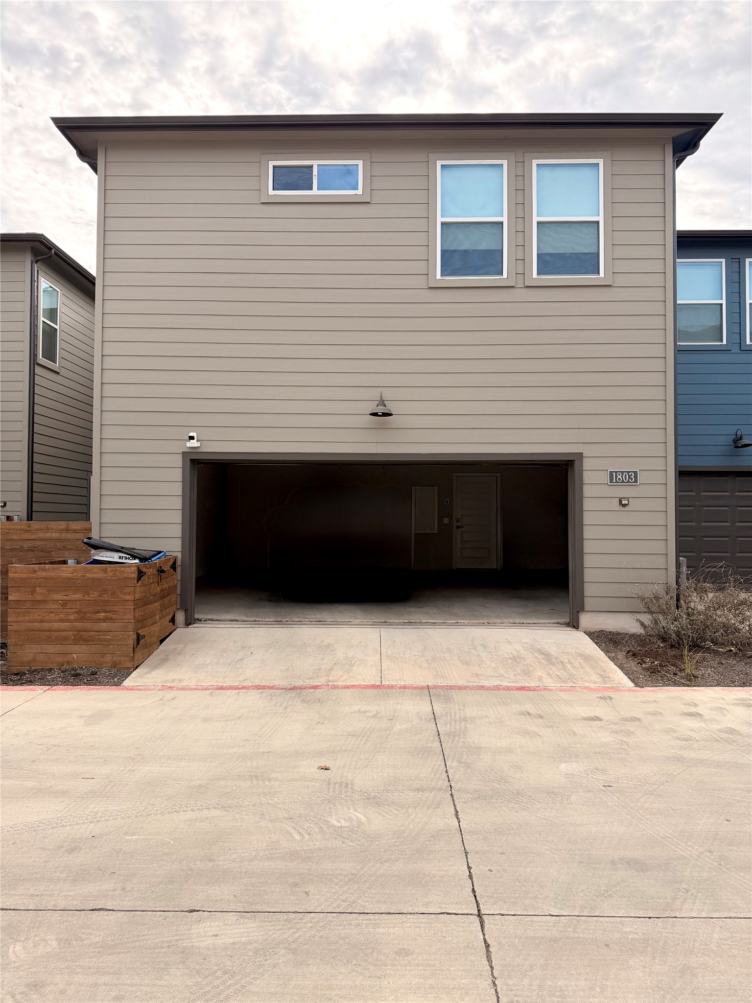9015 Cattle Baron Path, Unit 1803 Austin, TX 78747 - Photo 20 of 23 View of side of home featuring an attached garage and concrete driveway
