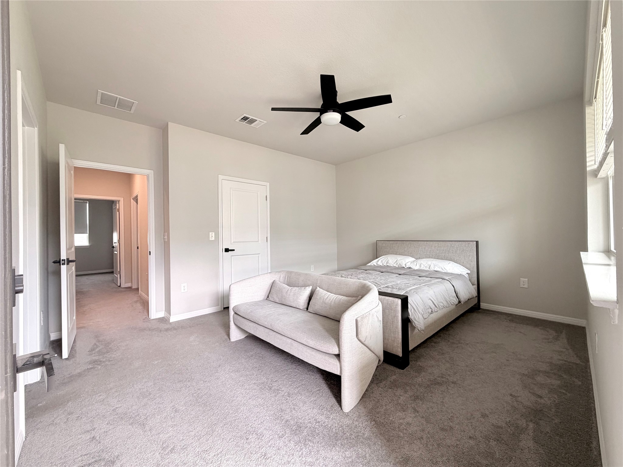 9015 Cattle Baron Path, Unit 1803 Austin, TX 78747 - Photo 9 of 23 Primary bedroom featuring light carpet and a ceiling fan (Queen size bed for reference. Can easily accommodate a king size bed and other furniture)