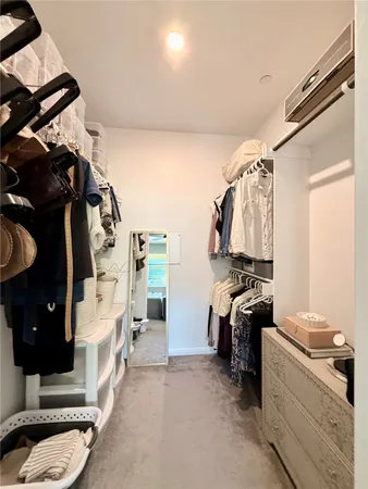 a view of walk in closet with clothes and shoes