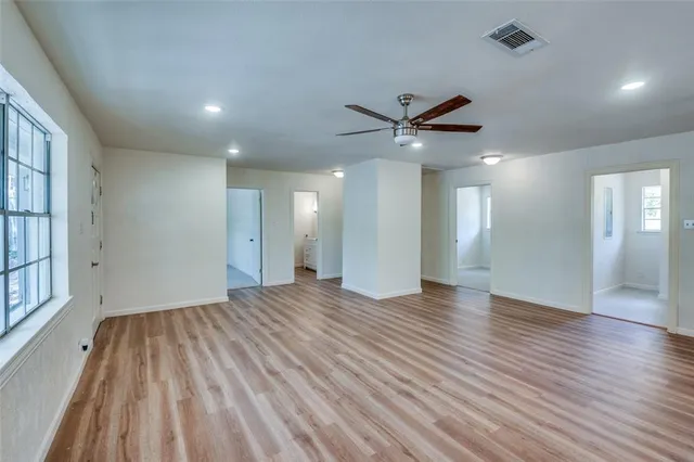 a view of a livingroom with a ceiling fan window and wooden floor
