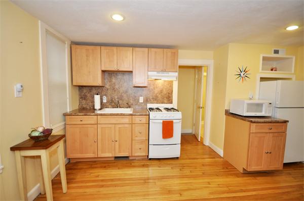 526 Centre Street, Unit 5 Boston, MA 02130 - Photo 8 of 14 a kitchen with stainless steel appliances granite countertop a stove a sink dishwasher and a refrigerator with wooden floor