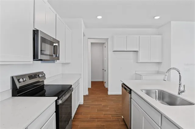 a kitchen with a sink stove and refrigerator